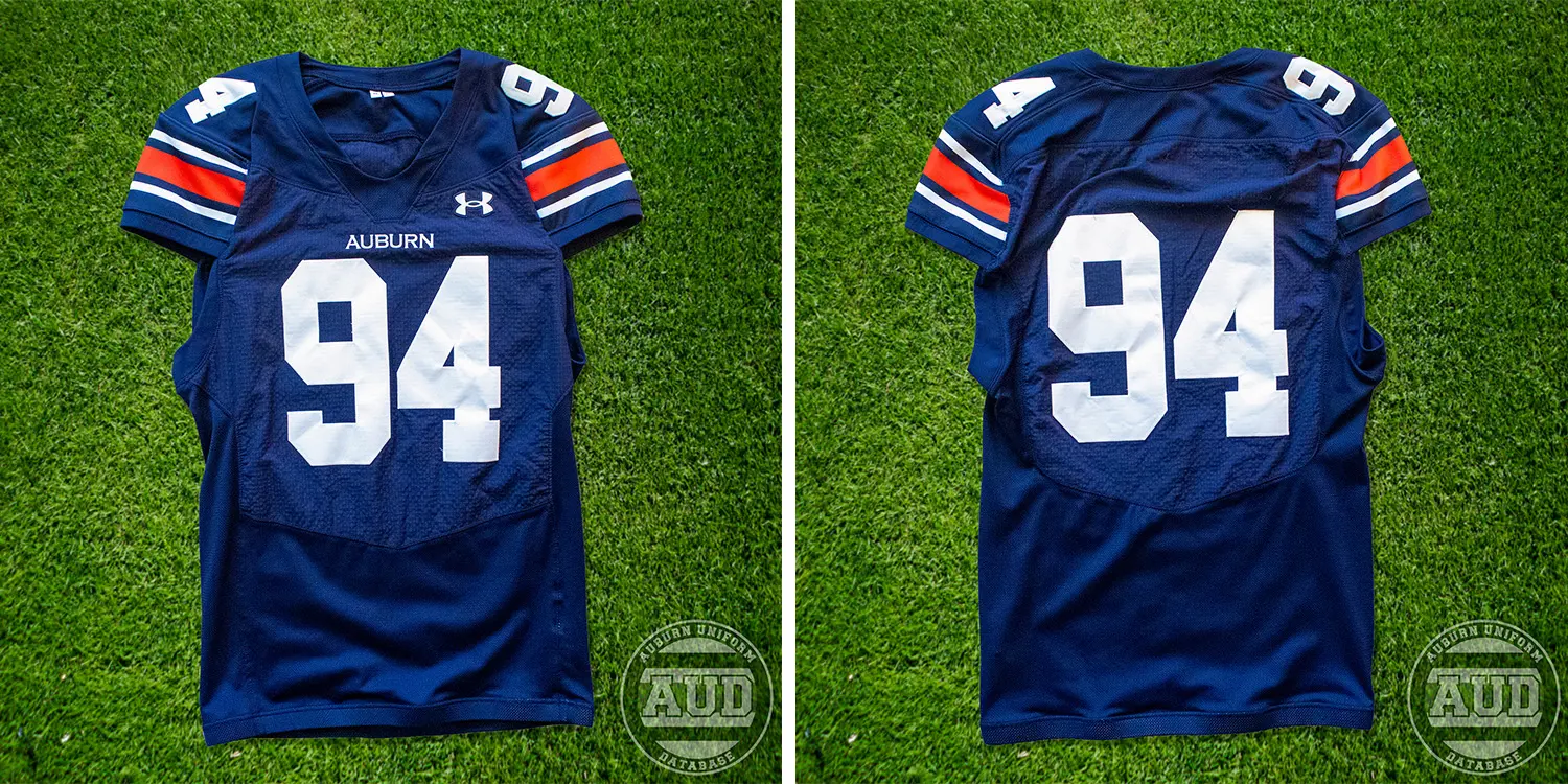 A 2024 Auburn Football navy Under Armour jersey #94 photographed on grass.